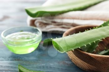 Bowl with fresh aloe vera leaves on wooden table�