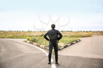 Young man standing at crossroads. Concept of choice�
