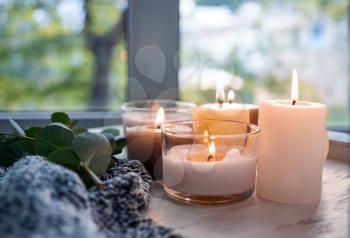Beautiful burning candles on wooden table�
