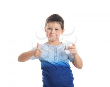Little boy with glass of fresh water showing thumb-up gesture on white background�