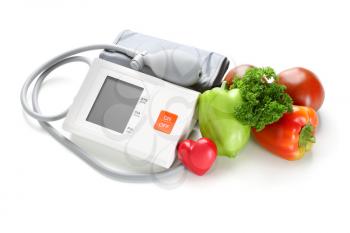 Sphygmomanometer with red heart and vegetables on white background�