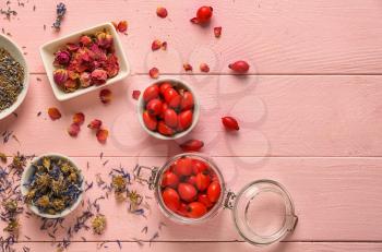 Dried flowers and rose hips on color wooden table�
