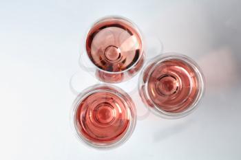 Glasses of pink wine on white background, top view�