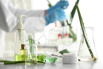 Cosmetic products with aloe on table in laboratory�