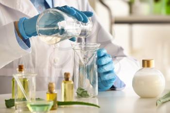 Woman making organic cosmetics with aloe in laboratory�