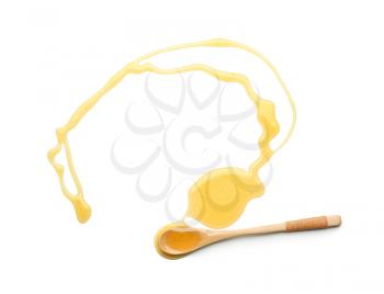 Wooden spoon and spilled honey on white background�