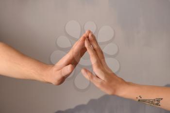 Man and woman touching fingers on grey background�