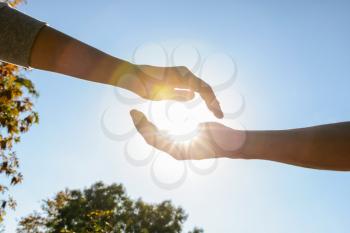 Male and female hands with sun outdoors�