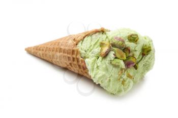 Waffle cone with delicious ice cream and pistachios on white background�