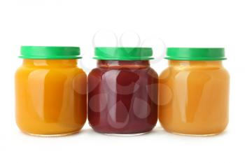 Glass jars with healthy baby food on white background�