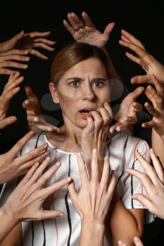 Many hands stretched to woman on dark background. Panic attack�