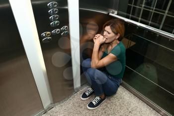 Woman having panic attack in elevator�