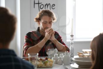 Family praying before meal at home�