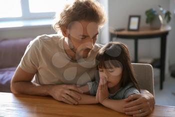 Father with daughter praying at home�