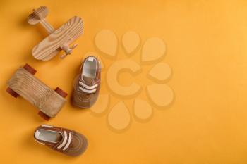 Baby shoes and toys on color background, flat lay�
