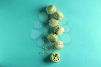 Fresh tasty macaroons on color background�