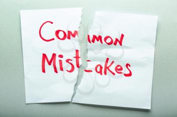 Torn sheet of paper with text COMMON MISTAKES on light background�