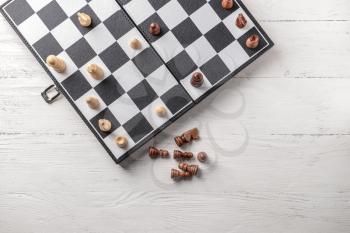 Game board with chess pieces on white wooden table�