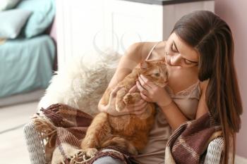 Woman with cute cat resting at home�