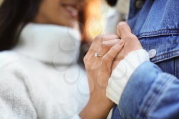 Young man with his beloved wearing engagement ring, closeup�