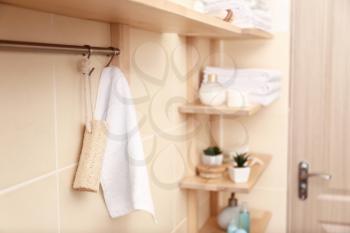 Rack with white terry towel and loofah in bathroom�