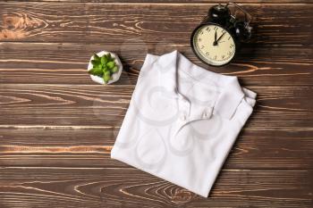 Child t-shirt with alarm clock on wooden background�
