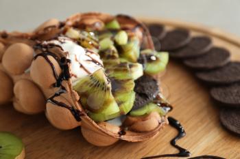 Delicious sweet bubble waffle on wooden board, closeup�