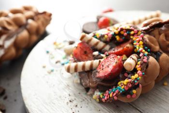 Delicious bubble waffle on wooden board, closeup�