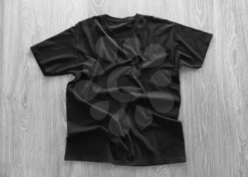 Blank black t-shirt on wooden background�