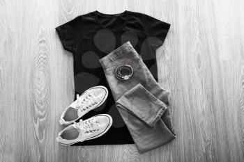 Stylish outfit with shoes and watch on wooden background�