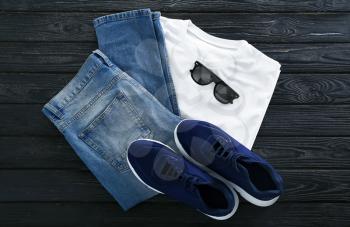 Stylish outfit with shoes and sunglasses on wooden background�