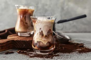 Glass with cold coffee on grey table�