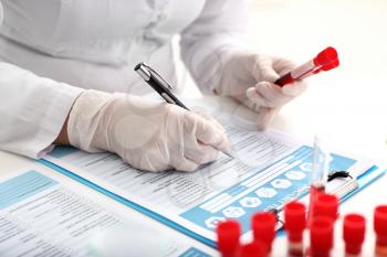 Woman working with blood samples in laboratory, closeup�