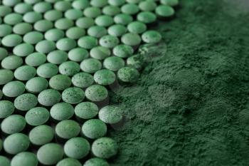 Spirulina tablets with powder, closeup�