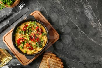 Pan with tasty omelet on grey table�