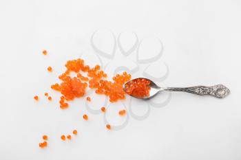Spoon with delicious red caviar on white background�