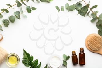 Composition with cosmetics and eucalyptus branches on white background�