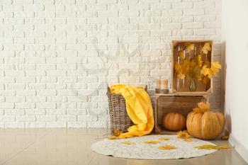 Beautiful autumn composition with pumpkins and leaves near white brick wall�