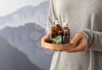Woman with bottles of eucalyptus essential oil, closeup�