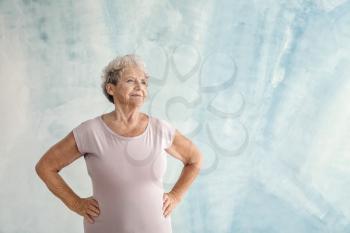 Portrait of senior woman on color background�