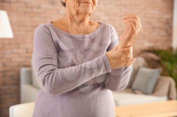 Senior woman suffering from pain in wrist at home�