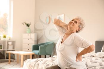Senior woman suffering from back pain at home�