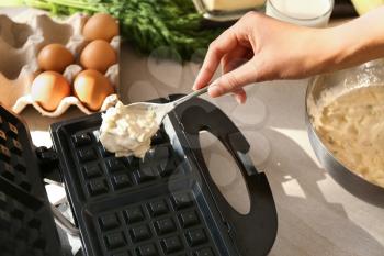 Woman preparing waffles in modern maker�