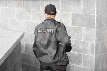 Male security guard outdoors, back view�
