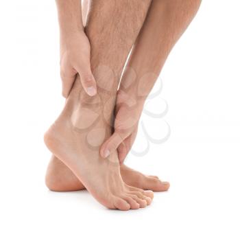 Young man suffering from pain in leg on white background�