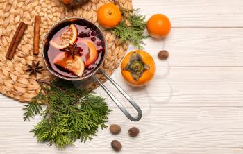 Pot of tasty mulled wine and ingredients on table�