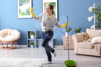 Young woman having fun while cleaning her flat�