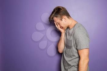 Portrait of stressed young man on color background�