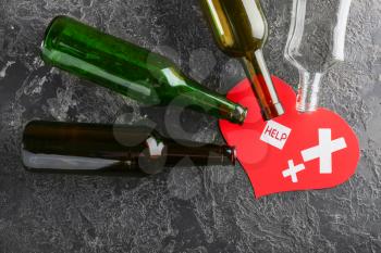 Empty bottles with paper heart on grunge background. Concept of alcoholism�
