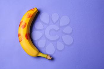 Fresh banana with lipstick prints on color background. Erotic concept�